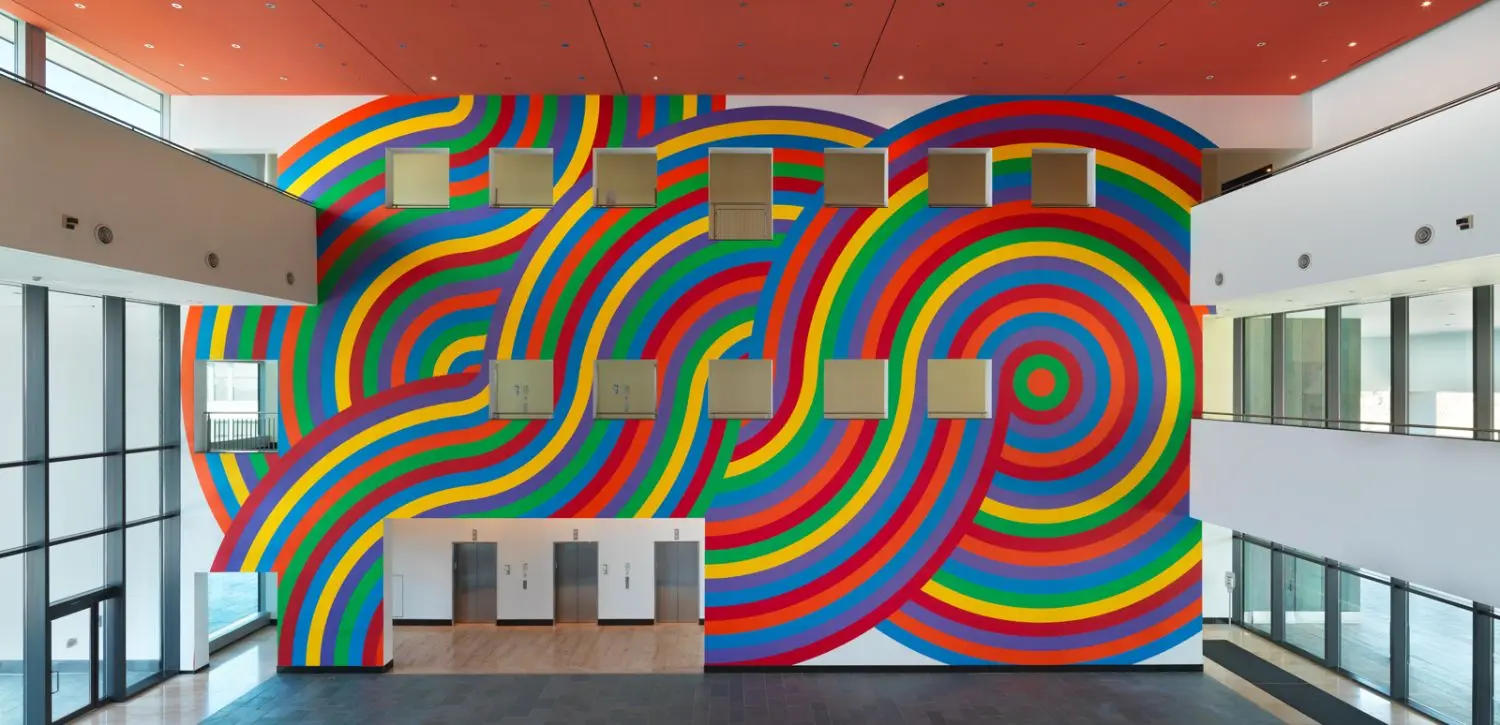 Vast thick bands of bright, vibrant colours − yellow, red, purple, green, orange and blue sweep, swirl and undulate in gracious, serpentine lines from ceiling to floor across the large wall of the entrance hall of our Armonk office.